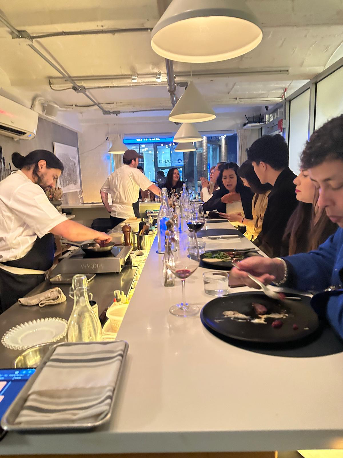 Elegant dining atmosphere at Pearl Street showing the modern chef's counter setup with guests enjoying an intimate culinary experience